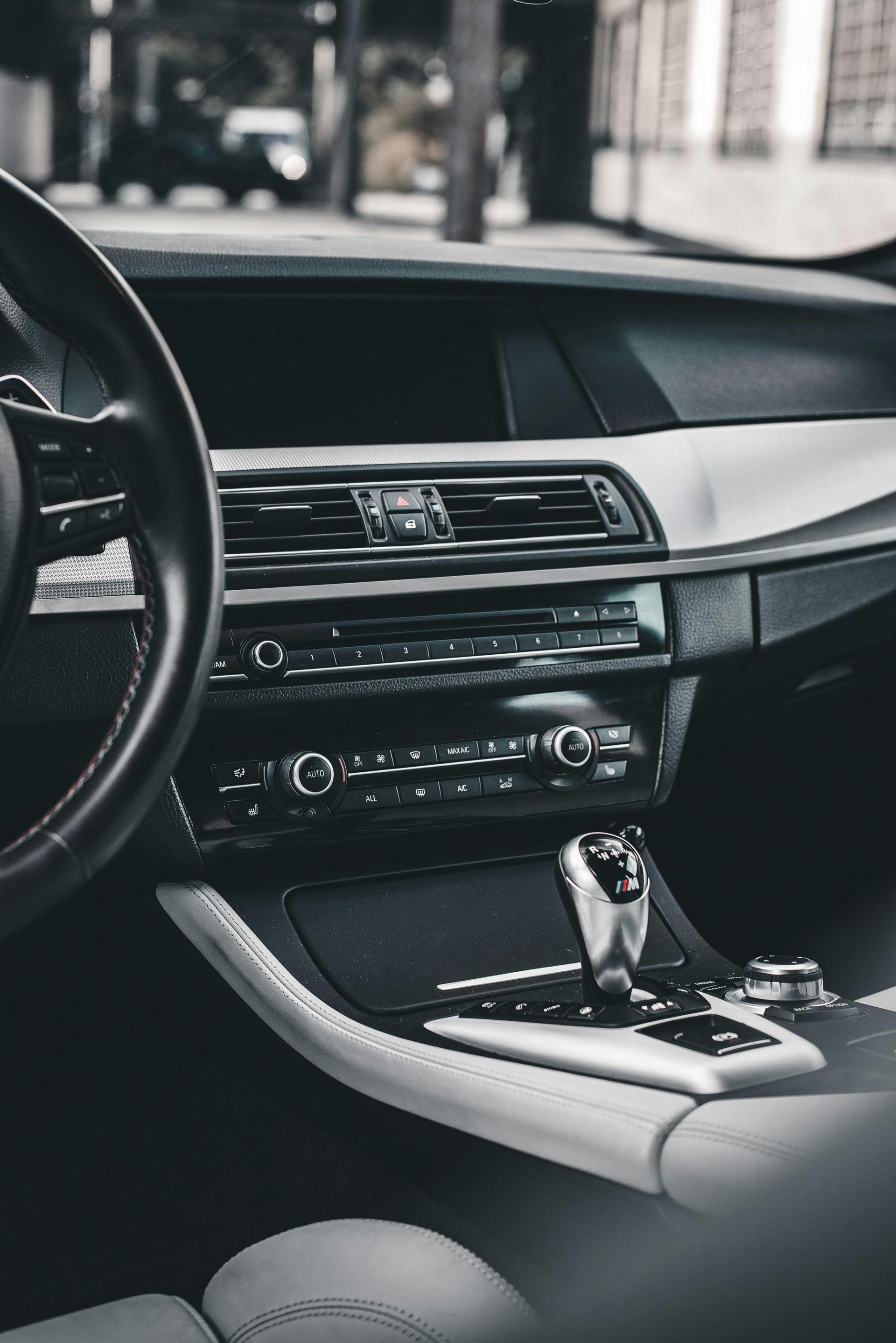 Interior of a black and silver car, featuring the dashboard, steering wheel, and gear shift.